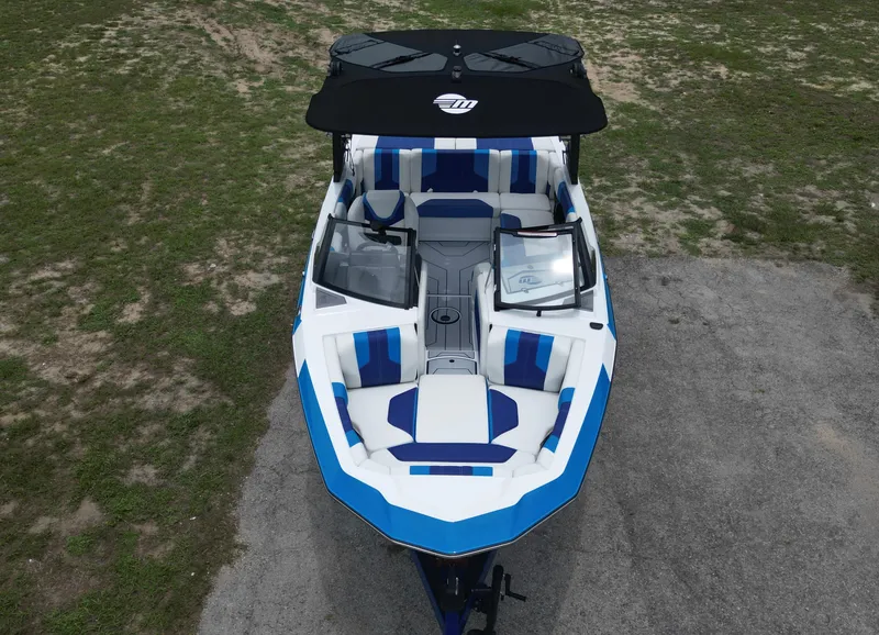 Slide: The Image of 2024 Malibu Wakesetter 21 LX boat, top view, blue and white interior, on land. - 7