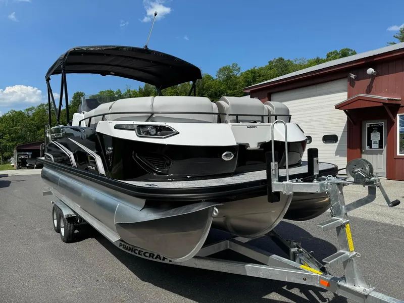 Slide: The Image of 2024 Princecraft VOGUE 23RL pontoon boat on a trailer outside a building. - 4