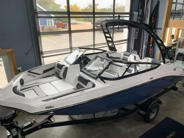 Slide: The Image of 2024 Yamaha Boats 195S in showroom, blue and white exterior, sleek design. - 1