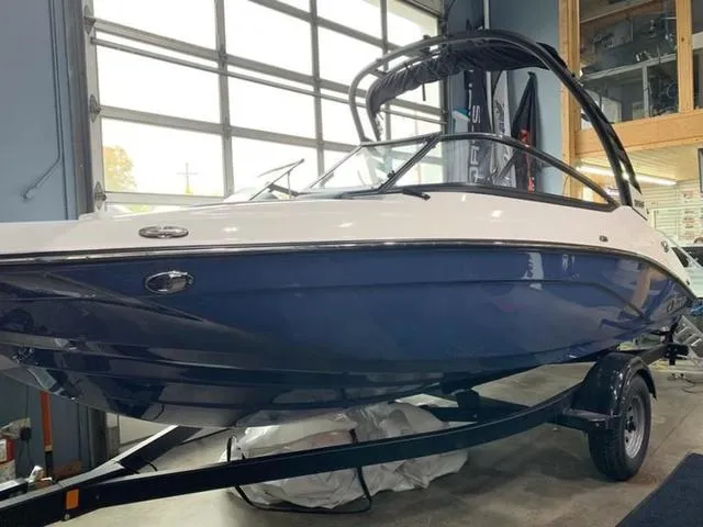 Slide: The Image of 2024 Yamaha Boats 195S in showroom, blue and white exterior. - 2
