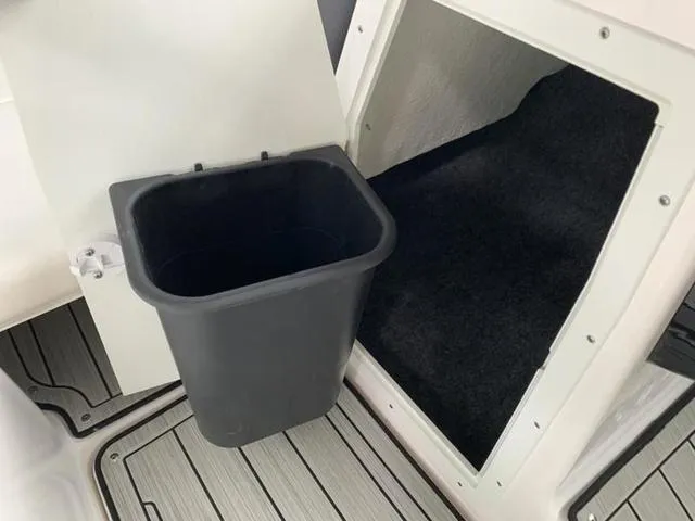 Slide: The Image of 2024 Yamaha Boats 195S storage compartment with trash bin. - 8