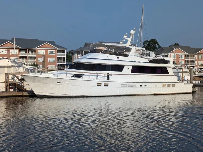 Slide: The Image of 1989 Hatteras Cockpit Motoryacht docked at marina with waterfront buildings. - 1