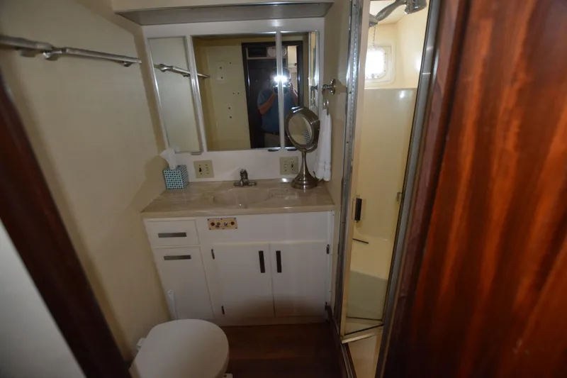 Slide: The Image of 1989 Hatteras Cockpit Motoryacht bathroom with sink, mirror, and shower. - 15