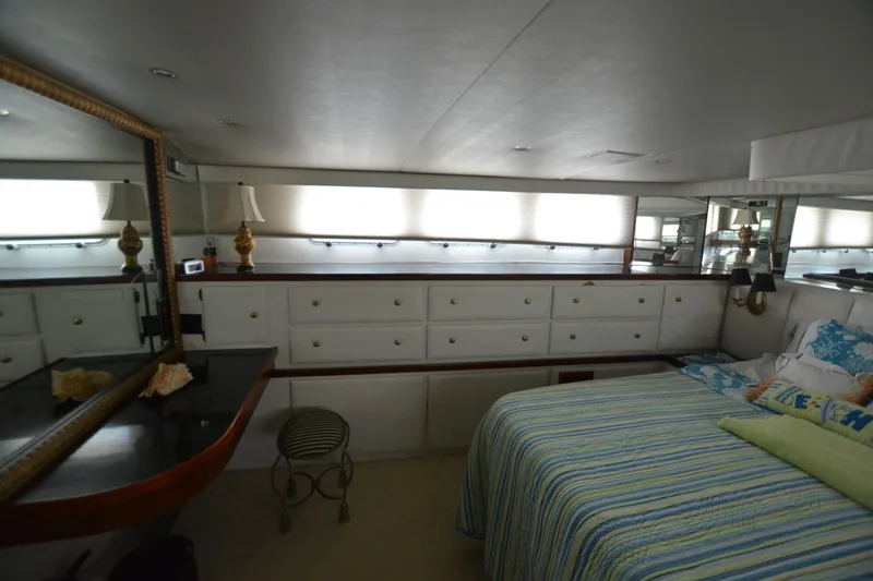 Slide: The Image of Luxurious bedroom interior of 1989 Hatteras Cockpit Motoryacht with striped bedding and elegant decor. - 22
