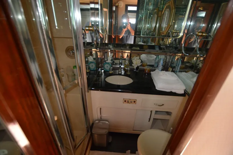 Slide: The Image of Luxurious bathroom in 1989 Hatteras Cockpit Motoryacht with mirrored walls and modern amenities. - 25