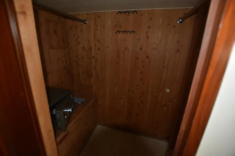 Slide: The Image of Wood-paneled interior of 1989 Hatteras Cockpit Motoryacht, featuring storage space. - 26