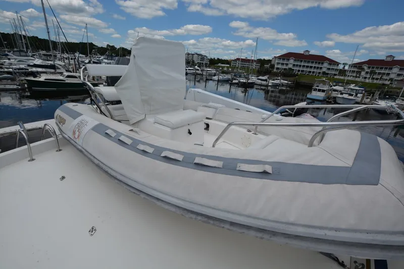 Slide: The Image of 1989 Hatteras Cockpit Motoryacht with inflatable boat on deck, docked at marina. - 4
