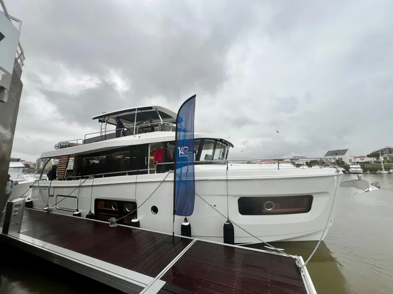 Slide: The Image of 2025 Beneteau Swift Trawler 54 docked on a cloudy day. - 0