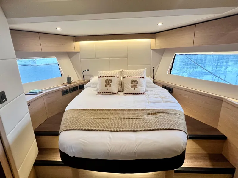 Slide: The Image of Luxurious bedroom in 2025 Beneteau Swift Trawler 54 with large windows and modern decor. - 15