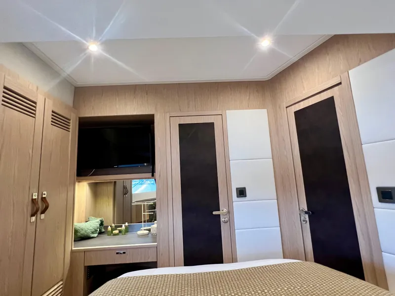 Slide: The Image of 2025 Beneteau Swift Trawler 54 bedroom with modern wood paneling and built-in TV. - 16