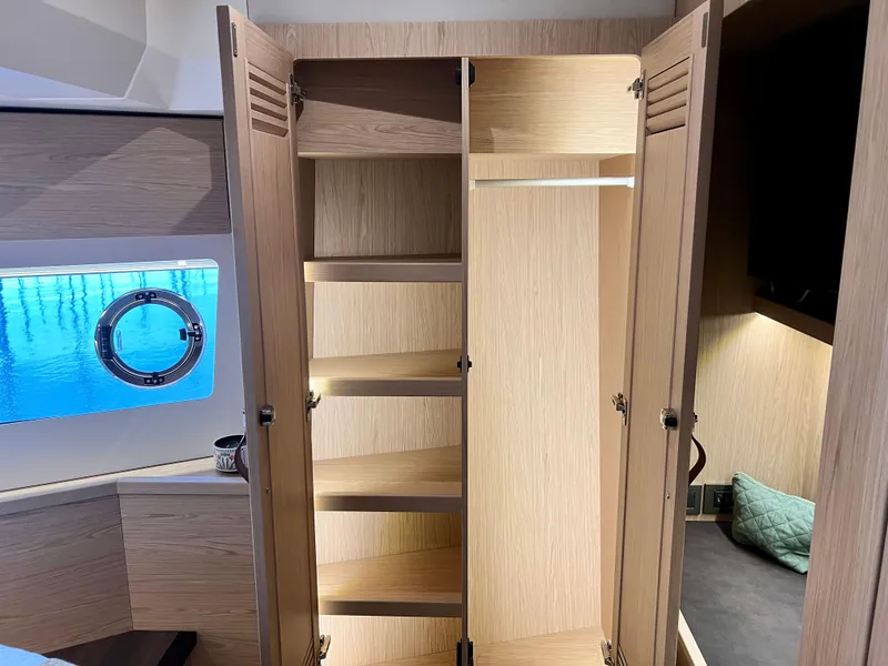 Slide: The Image of Open wooden closet with shelves inside a 2025 Beneteau Swift Trawler 54 yacht. - 17