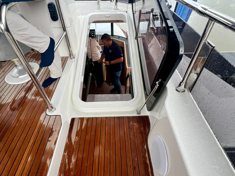 Slide: The Image of 2025 Beneteau Swift Trawler 54 interior view with wooden deck and stairs. - 29