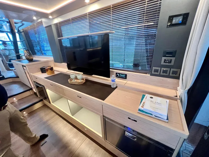 Slide: The Image of Modern interior of 2025 Beneteau Swift Trawler 54 with sleek cabinetry and TV. - 7