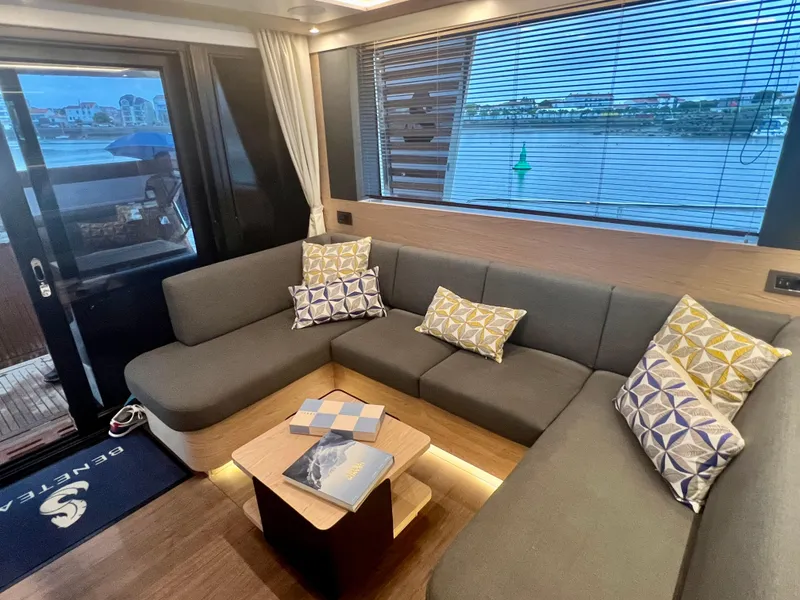 Slide: The Image of Interior of 2025 Beneteau Swift Trawler 54 with modern sofa and scenic window view. - 8
