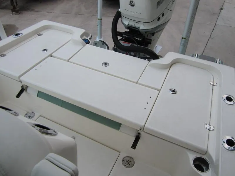 Slide: The Image of 2021 ShearWater 250 Carolina Bay boat deck with storage compartments and outboard motor. - 17