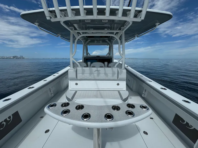 Slide: The Image of 2024 Yellowfin 39 boat with spacious deck and rod holders on calm ocean. - 15