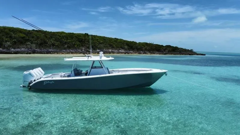 Slide: The Image of 2024 Yellowfin 39 boat anchored in clear turquoise water near a tropical island. - 6