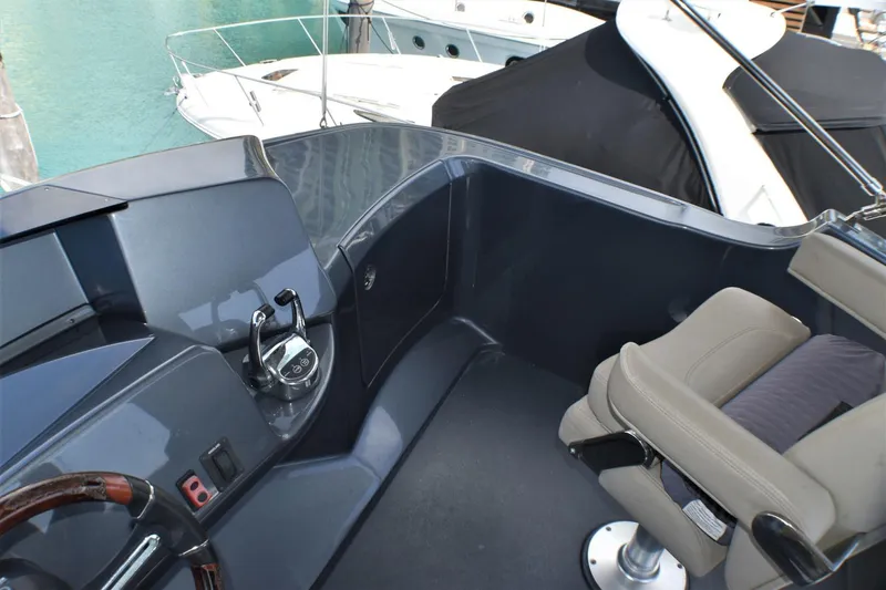 Slide: The Image of 2019 Silverton 41 Sport Bridge helm station with leather captain's chair and control panel. - 13