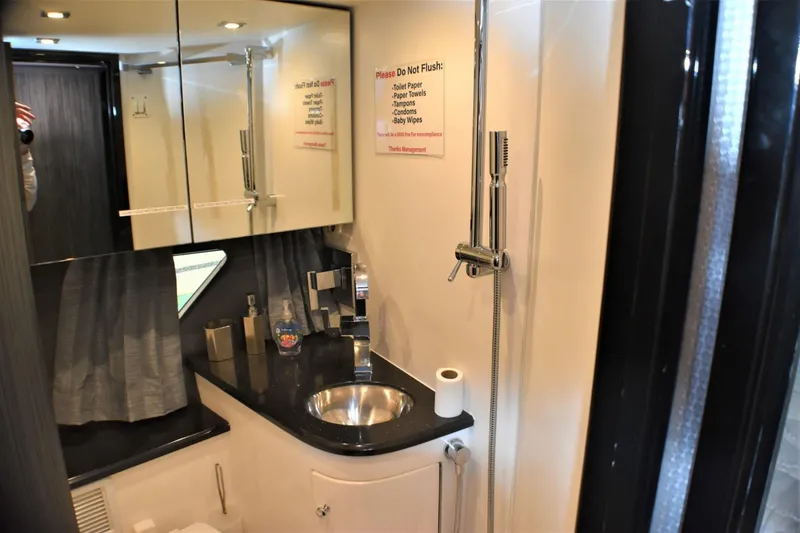 Slide: The Image of 2019 Silverton 41 Sport Bridge bathroom with modern fixtures and black countertop. - 18