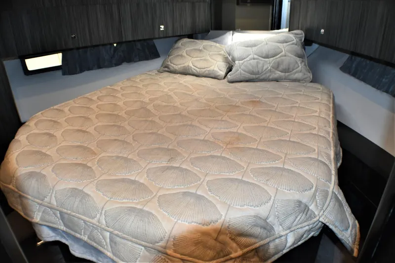 Slide: The Image of Cozy bedroom in 2019 Silverton 41 Sport Bridge yacht with quilted bedspread. - 26
