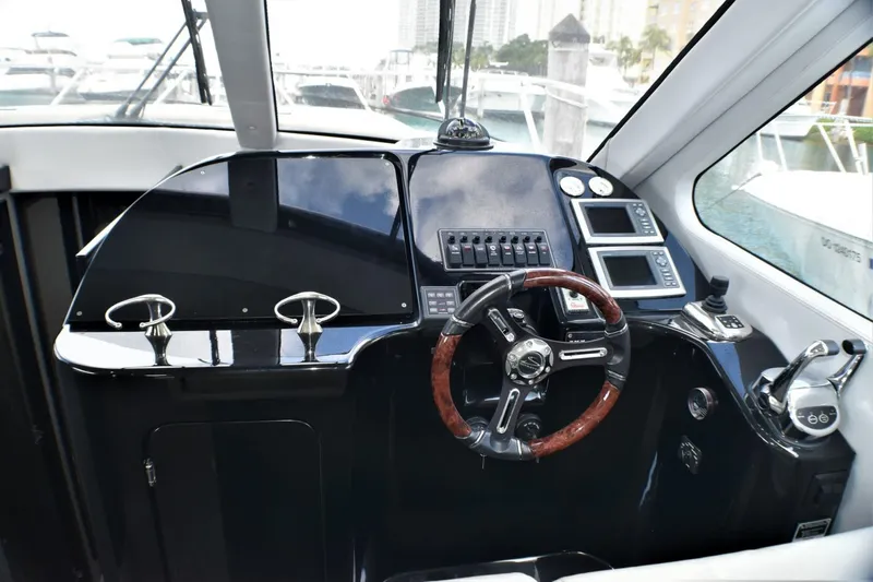 Slide: The Image of Helm station of 2019 Silverton 41 Sport Bridge with modern controls and wooden steering wheel. - 32