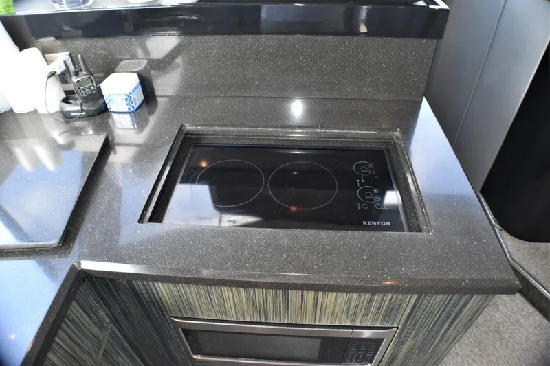 Slide: The Image of 2019 Silverton 41 Sport Bridge kitchen with Kenyon electric cooktop and microwave. - 40