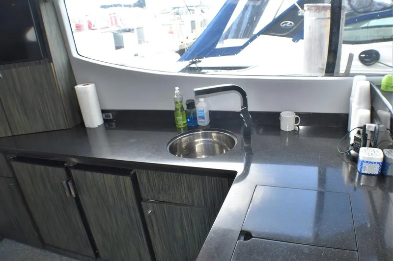 Slide: The Image of Modern kitchen area in 2019 Silverton 41 Sport Bridge yacht with sink and countertop. - 42