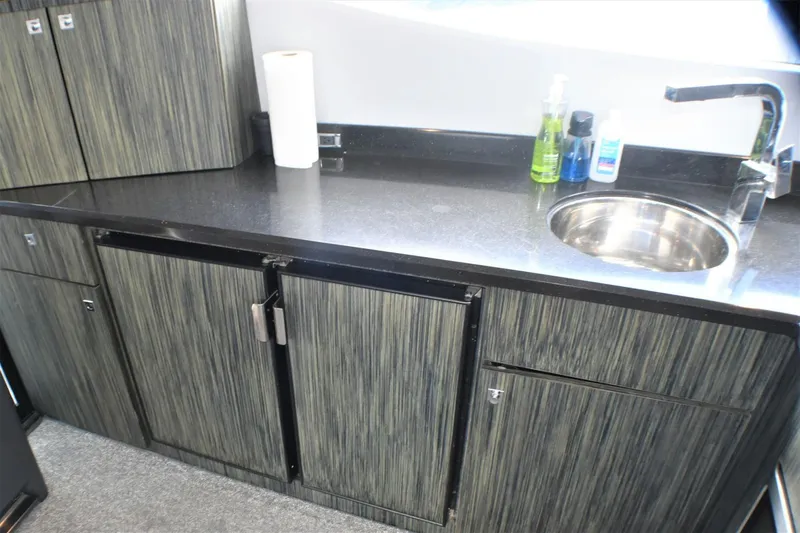 Slide: The Image of Modern kitchen area in 2019 Silverton 41 Sport Bridge yacht with sink and storage cabinets. - 43