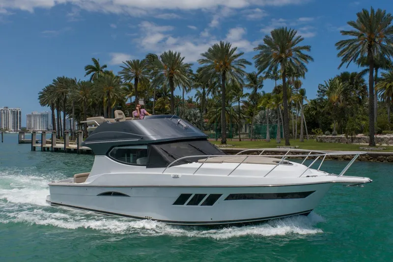 Slide: The Image of 2019 Silverton 41 Sport Bridge yacht cruising near palm trees. - 49