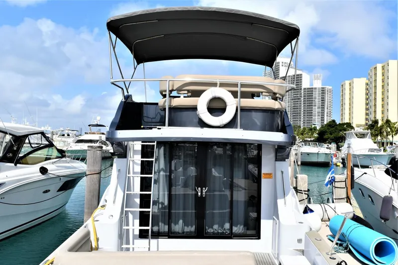 Slide: The Image of 2019 Silverton 41 Sport Bridge yacht docked at marina with city skyline. - 6