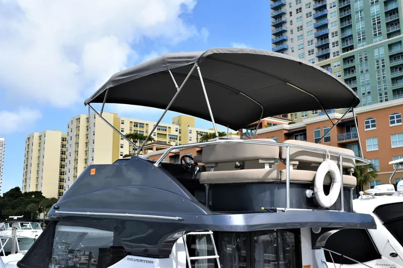 Slide: The Image of 2019 Silverton 41 Sport Bridge yacht docked in a marina with cityscape background. - 9