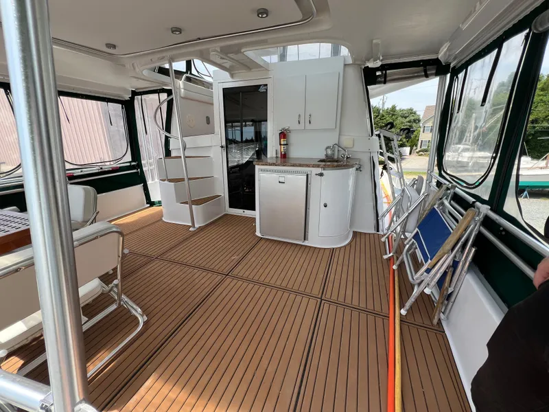 Slide: The Image of 1998 Mainship 47 Motor Yacht interior with wood flooring and kitchenette. - 11