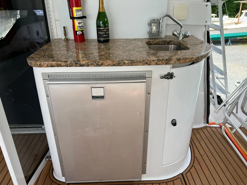 Slide: The Image of 1998 Mainship 47 Motor Yacht wet bar with granite countertop and stainless steel fridge. - 12