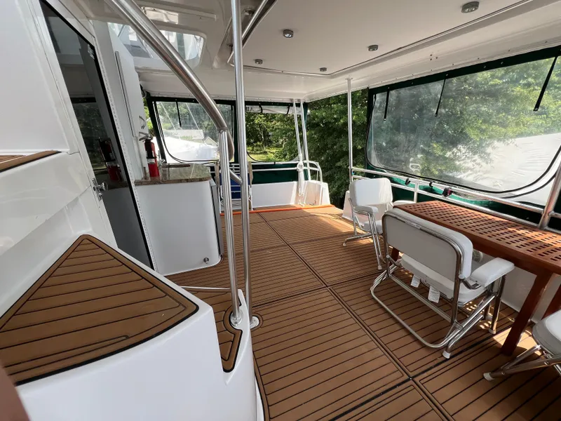 Slide: The Image of 1998 Mainship 47 Motor Yacht interior with wooden deck and seating area. - 15
