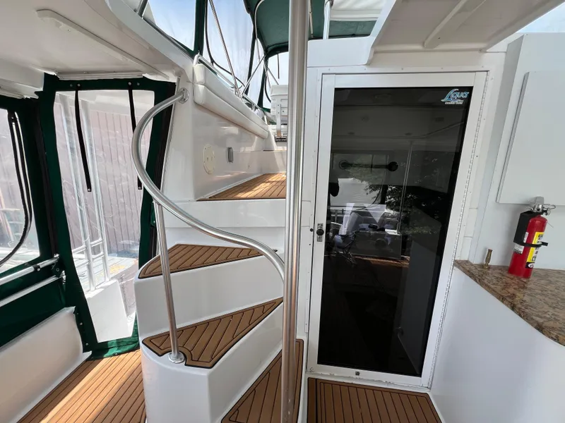 Slide: The Image of 1998 Mainship 47 Motor Yacht interior with spiral staircase and glass door. - 16