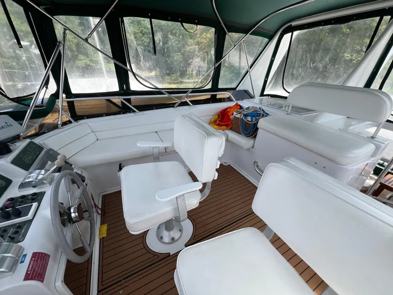 Slide: The Image of Interior of 1998 Mainship 47 Motor Yacht with white seating and wooden flooring. - 19