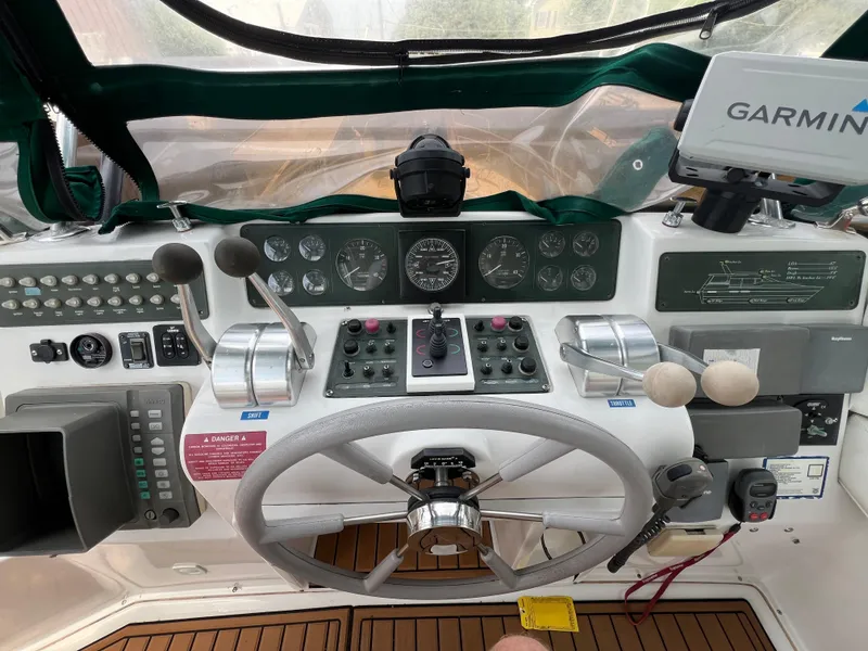 Slide: The Image of Control panel of a 1998 Mainship 47 Motor Yacht with steering wheel and navigation equipment. - 21