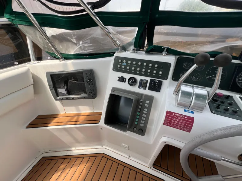 Slide: The Image of 1998 Mainship 47 Motor Yacht helm with navigation controls and wooden flooring. - 24