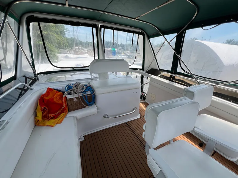 Slide: The Image of Interior of 1998 Mainship 47 Motor Yacht with white seating and wooden flooring. - 25