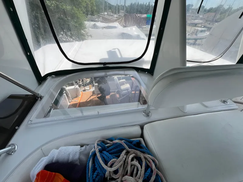 Slide: The Image of 1998 Mainship 47 Motor Yacht interior view with ropes and towels on seating area. - 26