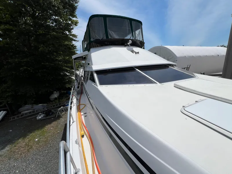 Slide: The Image of 1998 Mainship 47 Motor Yacht docked, featuring sleek design and spacious deck area. - 34