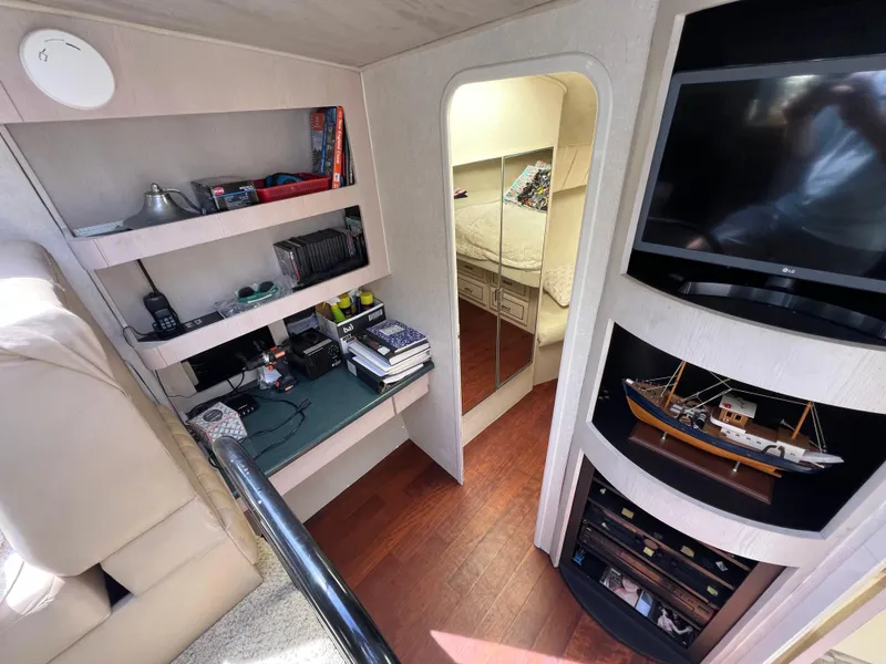 Slide: The Image of Interior of 1998 Mainship 47 Motor Yacht with shelves, TV, and model ship display. - 37