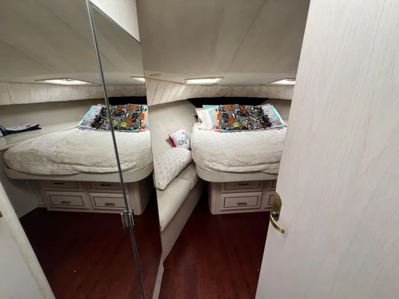 Slide: The Image of 1998 Mainship 47 Motor Yacht bedroom with cozy bed, colorful pillows, and wooden flooring. - 41
