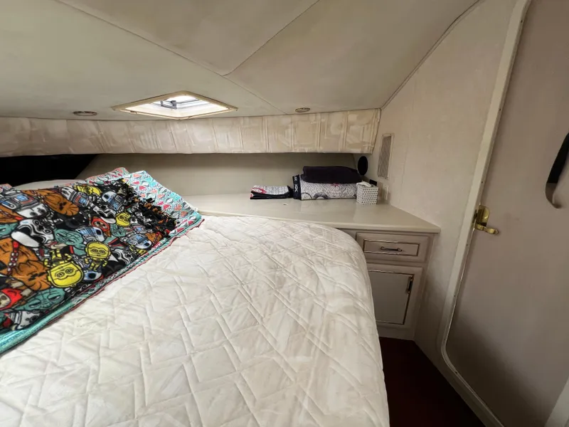 Slide: The Image of Cozy bedroom interior of 1998 Mainship 47 Motor Yacht with colorful bedding and storage. - 43