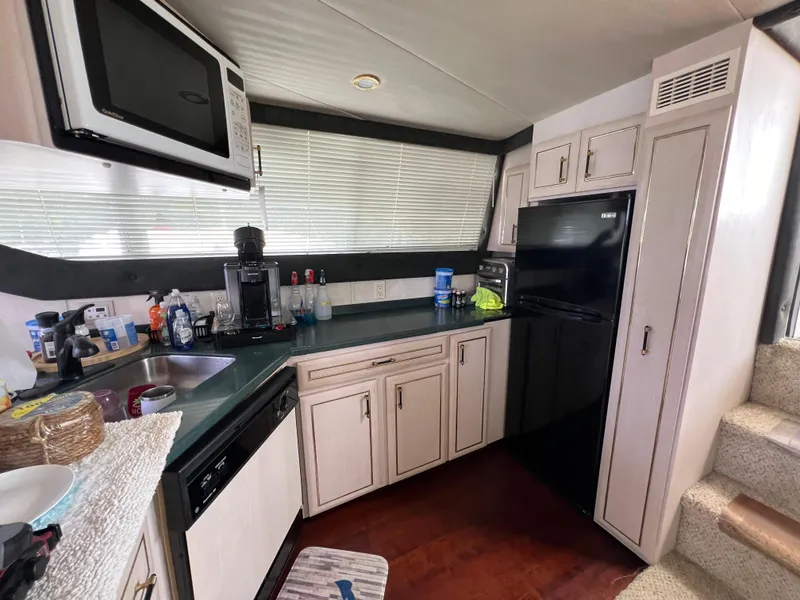 Slide: The Image of 1998 Mainship 47 Motor Yacht kitchen with microwave, fridge, and sink. - 47