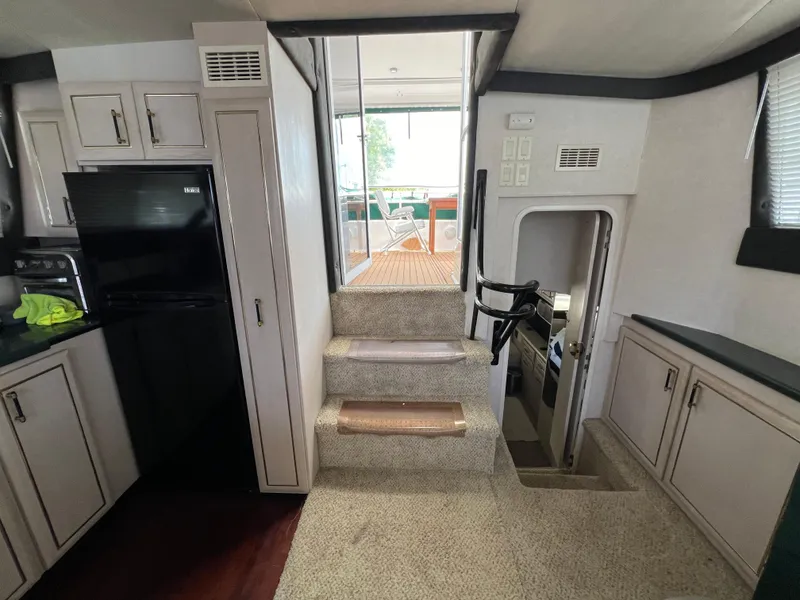 Slide: The Image of Interior of 1998 Mainship 47 Motor Yacht with stairs and kitchen area. - 48