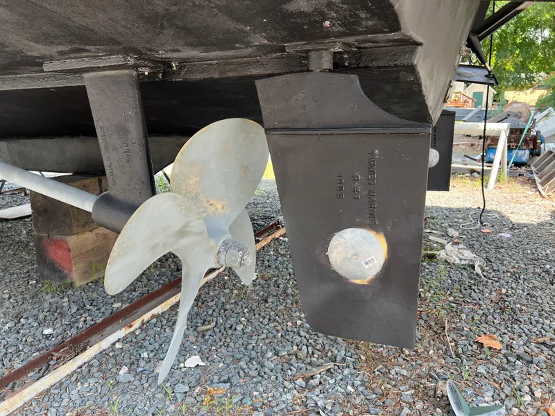 Slide: The Image of Propeller and rudder of a 1998 Mainship 47 Motor Yacht on gravel. - 8