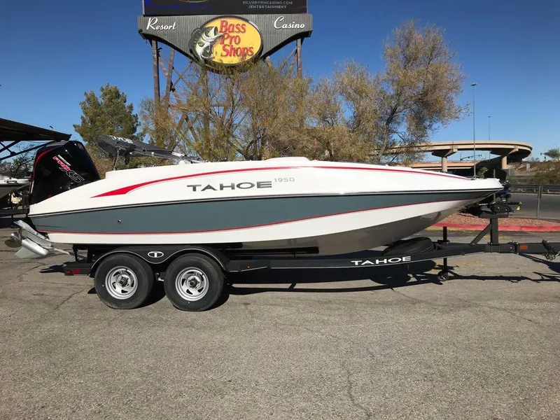 Slide: The Image of 2024 Tahoe 1950 boat on trailer near Bass Pro Shops sign. - 2