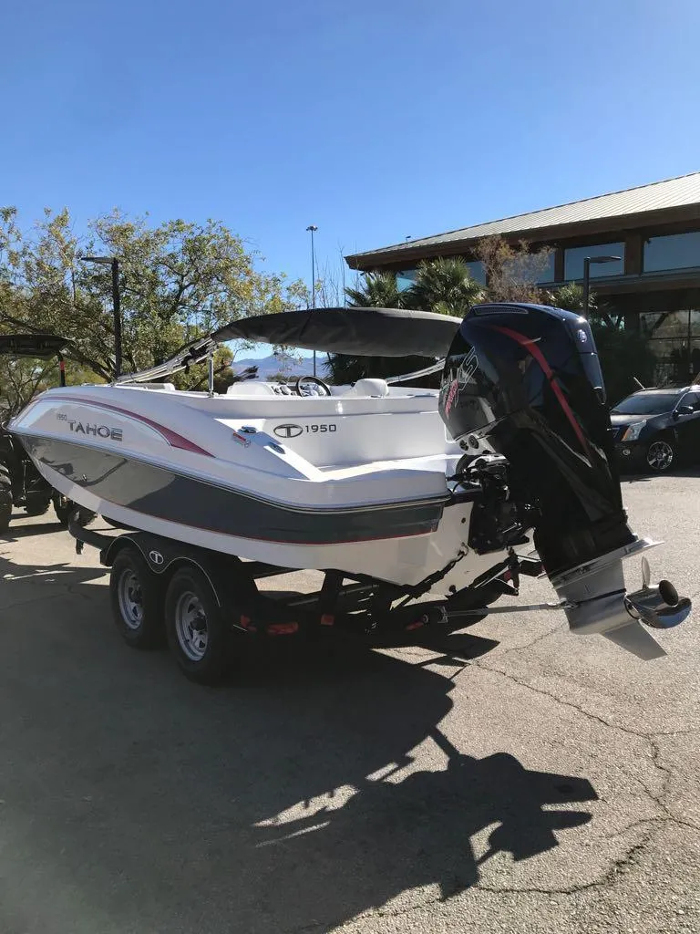 Slide: The Image of 2024 Tahoe 1950 boat on trailer, parked outdoors under clear blue sky. - 4