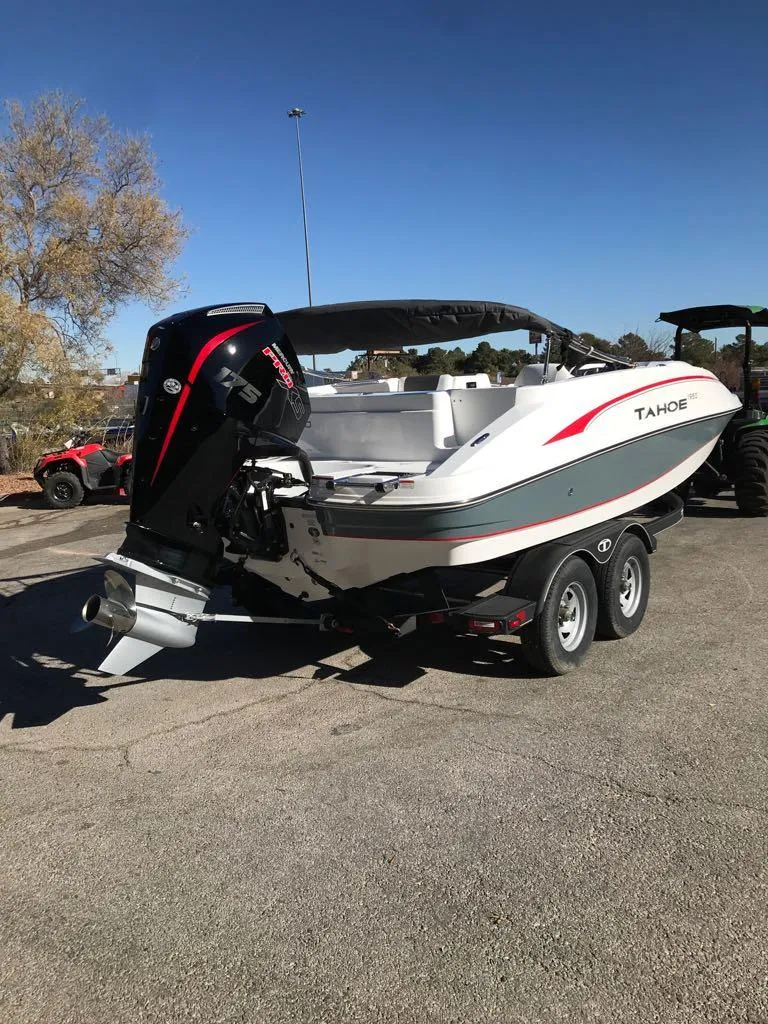 Slide: The Image of 2024 Tahoe 1950 boat on trailer, parked outdoors, featuring sleek design and powerful outboard motor. - 5
